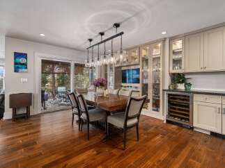 Experience elegant dining in this spacious room, featuring a large wooden table with comfortable upholstered chairs, perfect for hosting gatherings.