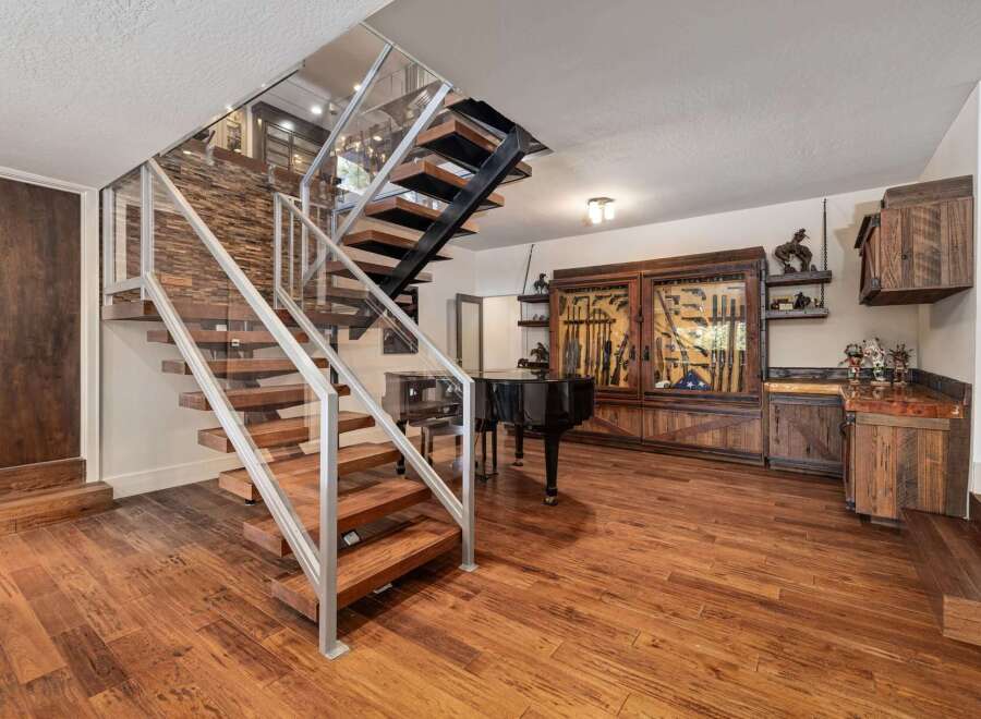 Experience luxury living with this stunning home featuring a modern floating staircase with glass railings and rich wood accents.