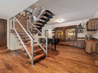Experience luxury living with this stunning home featuring a modern floating staircase with glass railings and rich wood accents.