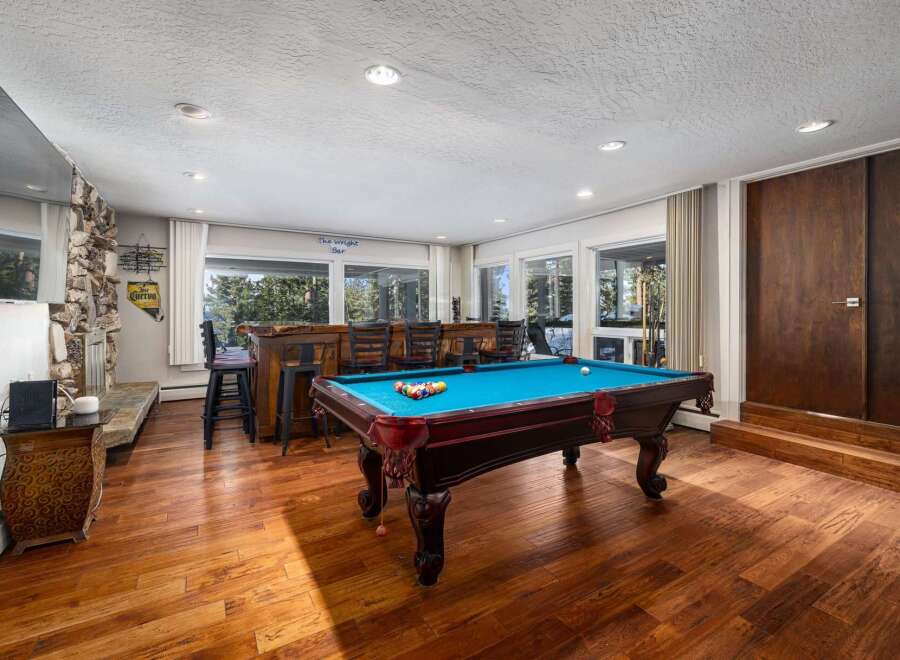 Experience ultimate entertainment in this stunning game room, featuring a vibrant blue felt pool table ready for action.