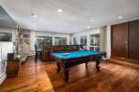 Experience ultimate entertainment in this stunning game room, featuring a vibrant blue felt pool table ready for action.