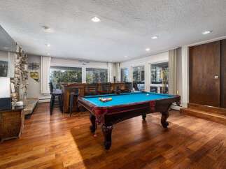 Experience ultimate entertainment in this stunning game room, featuring a vibrant blue felt pool table ready for action.