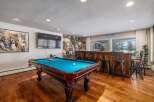 Experience ultimate entertainment in this game room featuring a pool table and a full-service bar.