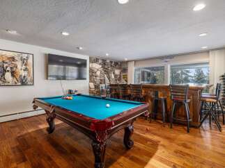 Experience ultimate entertainment in this game room featuring a pool table and a full-service bar.