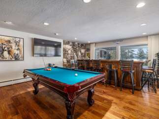 Experience ultimate entertainment in this game room featuring a pool table and a full-service bar.