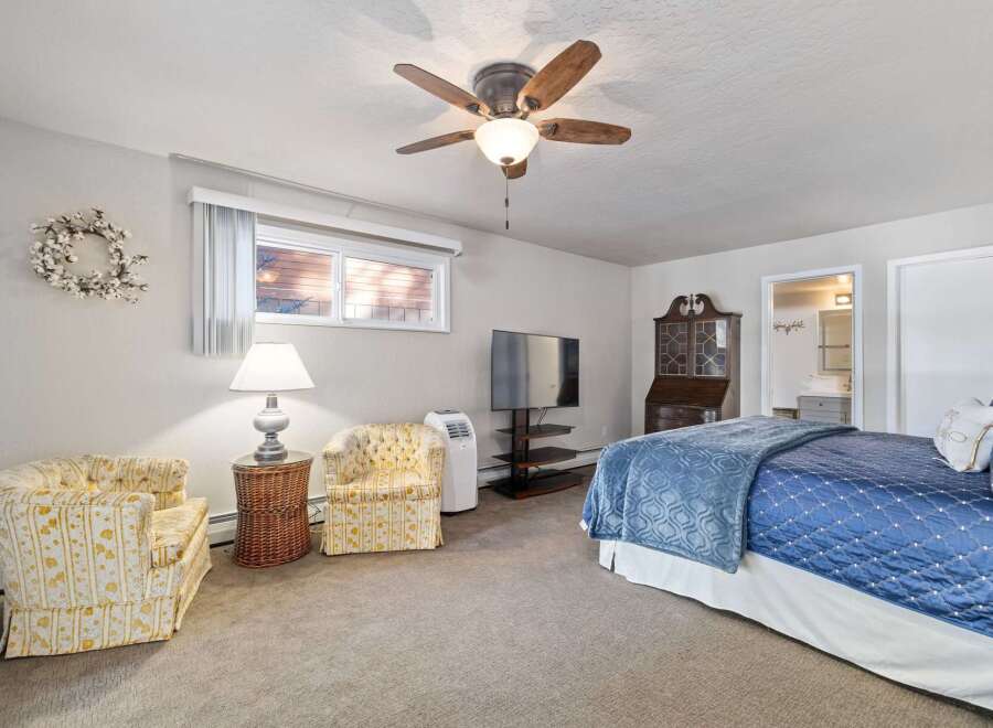 This charming bedroom offers a cozy retreat with a comfortable queen-sized bed adorned with a beautiful blue quilted comforter.