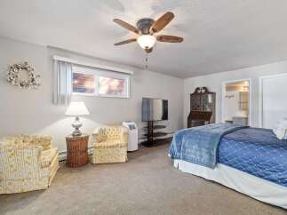 This charming bedroom offers a cozy retreat with a comfortable queen-sized bed adorned with a beautiful blue quilted comforter.