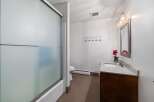 This bathroom features a frosted glass shower door and a clean white bathtub.