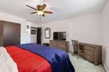 This cozy bedroom features a comfortable bed with vibrant red and blue bedding, perfect for relaxation.