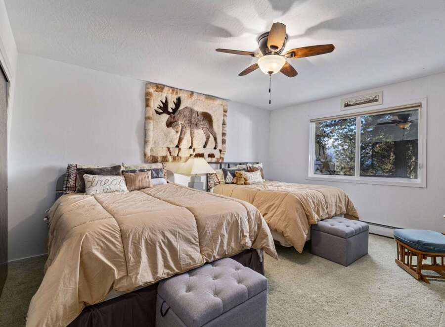 This charming bedroom features two comfortable beds adorned with plush bedding and decorative pillows, perfect for a restful night's sleep.
