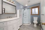 This modern bathroom features a spacious vanity with ample storage and a marble countertop, complemented by a large, ornate mirror.