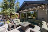 Enjoy outdoor living at its finest on this spacious deck, featuring a large sectional sofa and a stylish fire pit table perfect for gathering with loved ones.