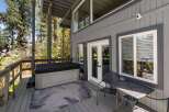 Enjoy outdoor living with this spacious deck featuring a relaxing hot tub and a charming patio set.