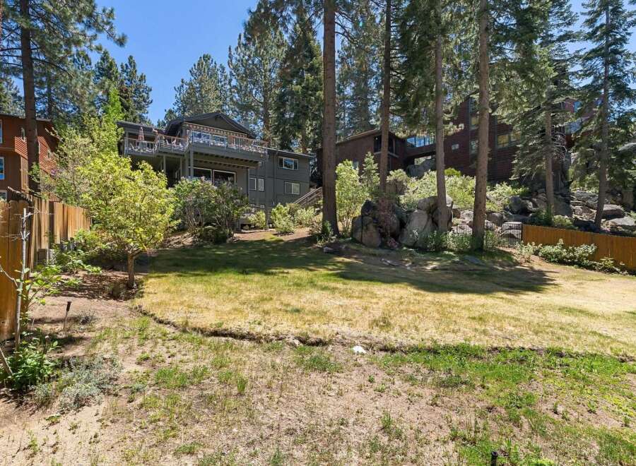 Nestled among tall pines, this multi-level home offers stunning views and ample outdoor living space.