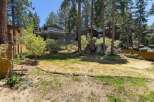Nestled among tall pines, this multi-level home offers stunning views and ample outdoor living space.