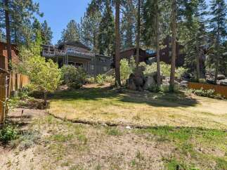 Nestled among tall pines, this multi-level home offers stunning views and ample outdoor living space.