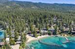 Experience luxury lakeside living with this stunning aerial view of a private beach and crystal-clear turquoise waters.