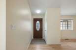 Step into a welcoming entryway featuring a beautiful wooden front door with decorative glass accents.