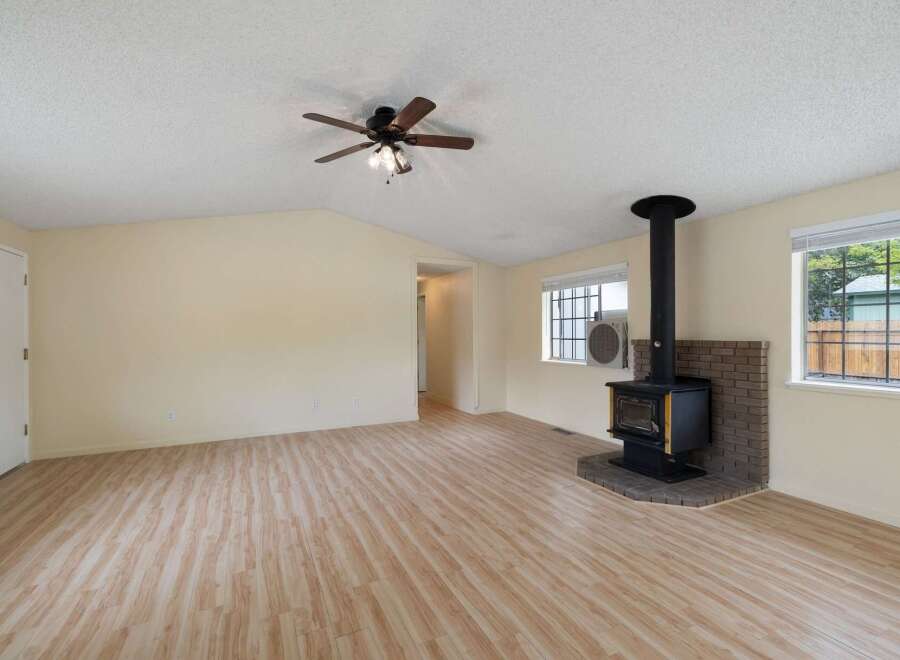 Discover this charming living space featuring a cozy wood-burning stove set against a brick hearth, perfect for warm gatherings.