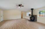 Discover this charming living space featuring a cozy wood-burning stove set against a brick hearth, perfect for warm gatherings.