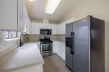 This charming kitchen features sleek white cabinetry and a spacious double sink with a modern gooseneck faucet.
