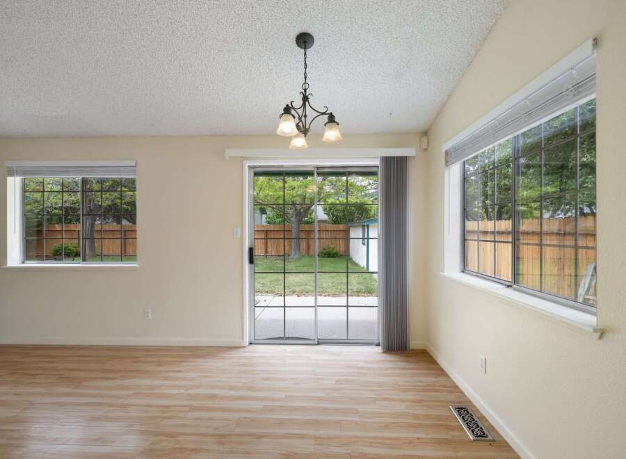 Step into this inviting living space featuring a charming brick fireplace and a large sliding glass door that opens to a private backyard.