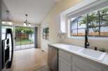 This kitchen features a spacious double sink with a modern black faucet, complemented by a stainless steel dishwasher.