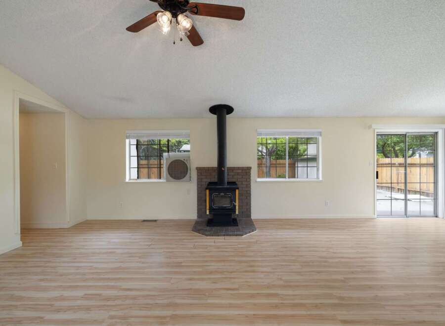 Discover this spacious living area featuring a cozy brick fireplace with a wood-burning stove, perfect for gathering on cooler evenings.