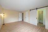 Step into this spacious room featuring a modern sliding barn door that leads to a private bathroom.