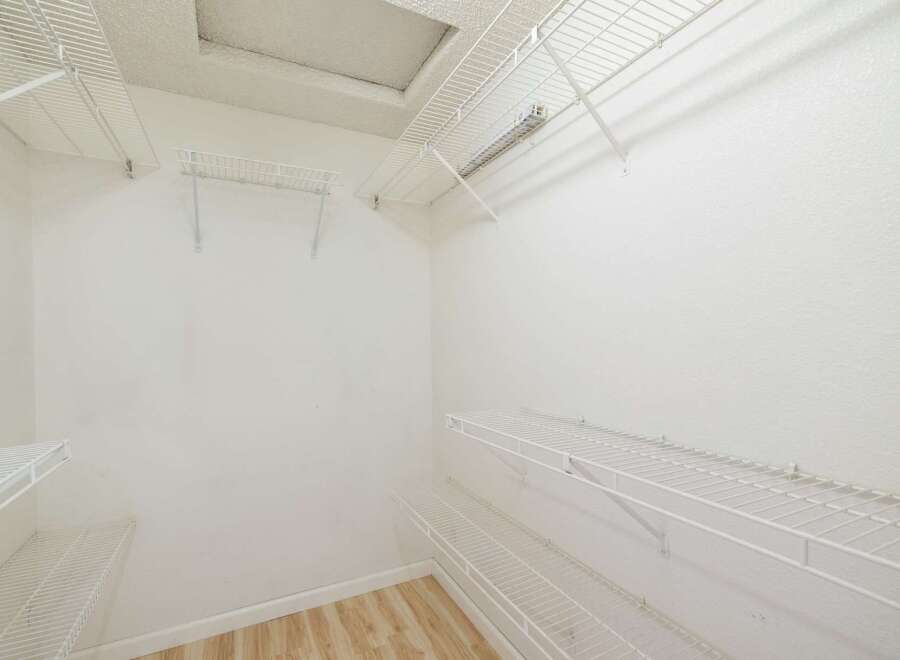 Discover ample storage solutions with this spacious walk-in closet, featuring multiple white wire shelving units.