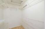 Discover ample storage solutions with this spacious walk-in closet, featuring multiple white wire shelving units.