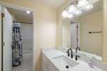 This bathroom features a sleek white vanity with a marble-look countertop and a modern black faucet.