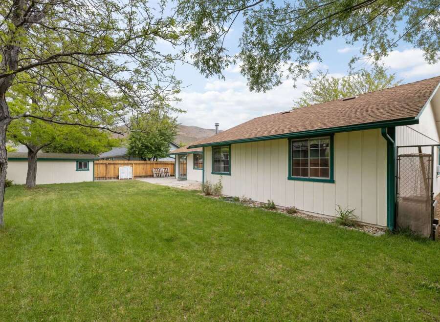 Enjoy the spacious backyard of this charming home, complete with a well-maintained lawn and mature trees offering ample shade.