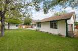 Enjoy the spacious backyard of this charming home, complete with a well-maintained lawn and mature trees offering ample shade.