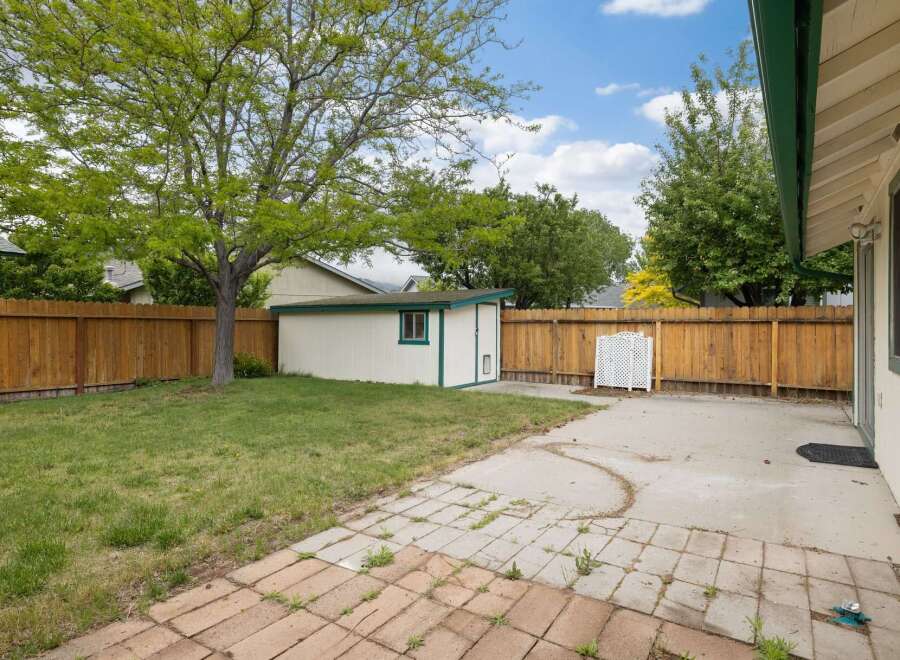Discover this charming backyard featuring a spacious lawn and a detached storage shed, perfect for outdoor enthusiasts.