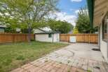 Discover this charming backyard featuring a spacious lawn and a detached storage shed, perfect for outdoor enthusiasts.