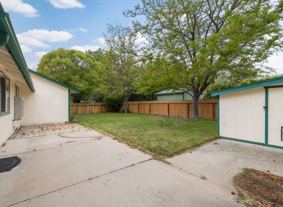 Discover this charming backyard featuring a well-maintained lawn, perfect for outdoor activities and relaxation.
