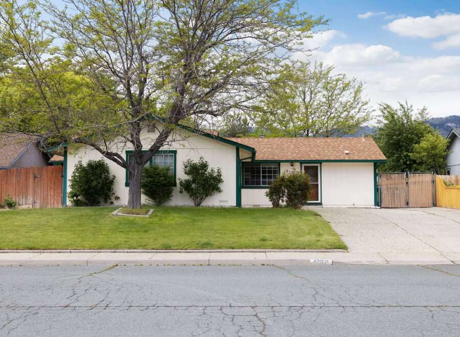 Charming single-story home with a welcoming facade and a well-maintained lawn.