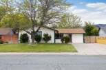 Charming single-story home with a welcoming facade and a well-maintained lawn.