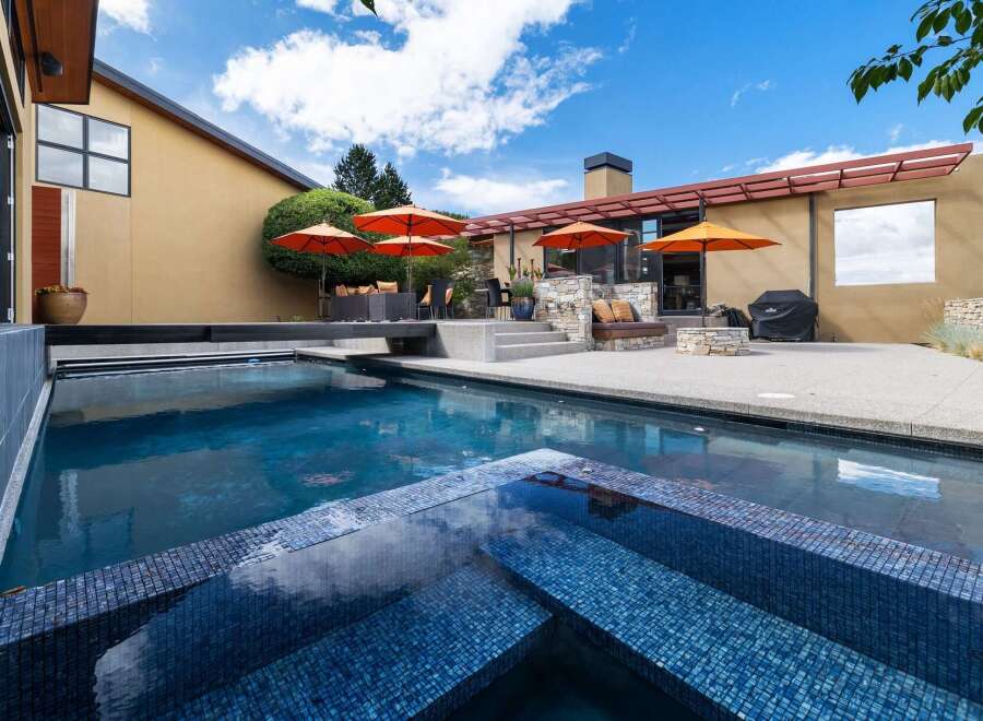 Experience luxury outdoor living with this stunning backyard oasis, featuring a sparkling swimming pool and integrated spa perfect for relaxation and entertainment.