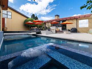 Experience luxury outdoor living with this stunning backyard oasis, featuring a sparkling swimming pool and integrated spa perfect for relaxation and entertainment.