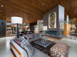 Experience luxury living in this stunning modern home featuring a dramatic floor-to-ceiling fireplace as the centerpiece of the living area.