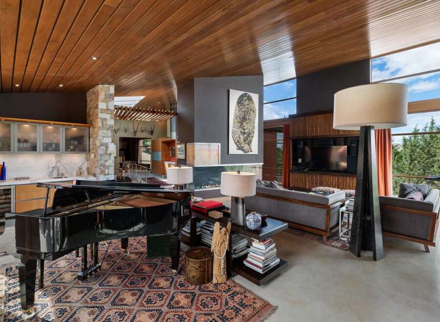 Experience luxury living in this stunning open-concept great room, featuring a grand piano and a modern fireplace.