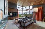 Experience breathtaking panoramic views from this stunning living room, featuring expansive floor-to-ceiling windows that frame a lush forest landscape.