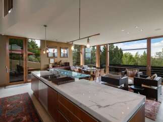 Experience modern living in this stunning open-concept home, featuring a gourmet kitchen with a marble island and sleek cabinetry.