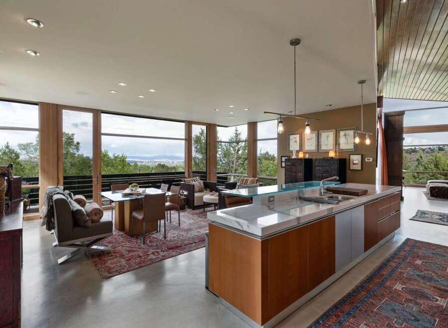 Experience modern living in this stunning open-concept space, featuring a gourmet kitchen with a marble island and sleek cabinetry, seamlessly flowing into a dining and living area.