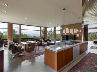 Experience modern living in this stunning open-concept space, featuring a gourmet kitchen with a marble island and sleek cabinetry, seamlessly flowing into a dining and living area.