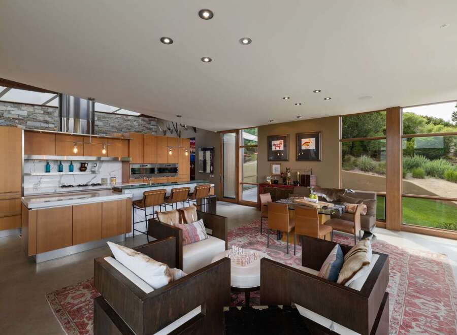 Experience modern living in this open-concept home featuring a gourmet kitchen with custom wood cabinetry and a sleek marble backsplash.