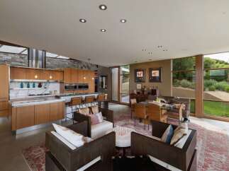 Experience modern living in this open-concept home featuring a gourmet kitchen with custom wood cabinetry and a sleek marble backsplash.