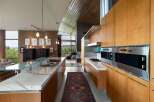 Experience modern luxury in this stunning open-concept kitchen, featuring sleek marble countertops and warm wood cabinetry.